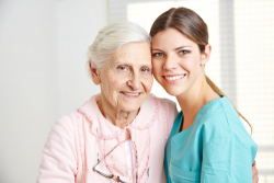 elderly woman with her caretaker smiling